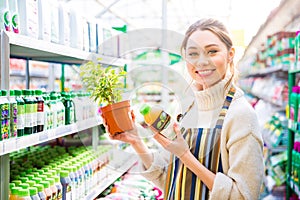 Happy woman gardener buying agricultural chemicals for plants