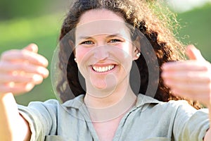 Happy woman gesturing come here in a park