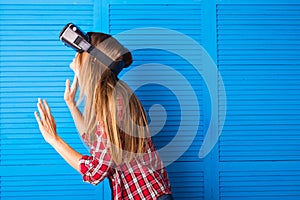 Happy woman getting experience using VR-headset glasses of virtual reality much gesticulating hands