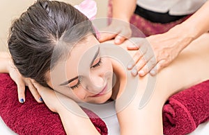 Happy woman is getting massage on a Spa bed with red toning