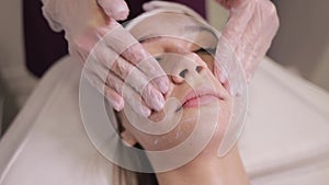 Happy woman getting pink cheek treatment at beauty salon