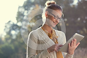 Happy woman in glasses using tablet pc photo