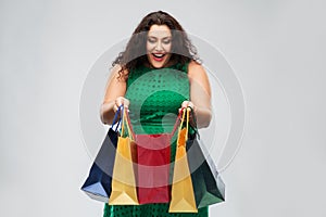 Happy woman in green dress with shopping bags