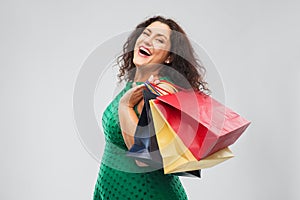 Happy woman in green dress with shopping bags