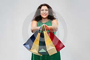 Happy woman in green dress with shopping bags