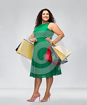 Happy woman in green dress with shopping bags