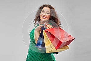 Happy woman in green dress with shopping bags