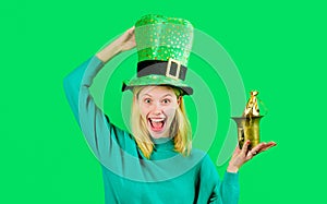 Happy woman in green top hat with small bag of gold. Patricks day celebration. Pot of money for Patrick's day party