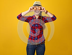 Happy woman grower holding eggs in front of face like eyes