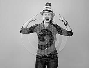 Happy woman grower isolated on yellow pointing on apple on head