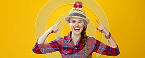 Happy woman grower isolated on yellow pointing on apple on head