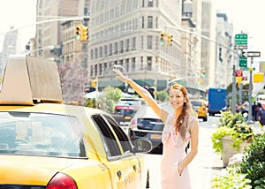 Happy woman hailing taxi cab in Manhattan New York city