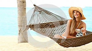 Happy woman on hammock at the exotic beach