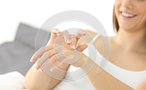 Happy woman hands applying moisturizer cream