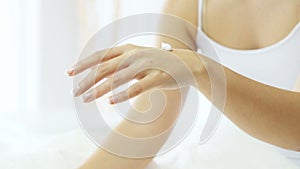 Happy woman hands applying moisturizer cream
