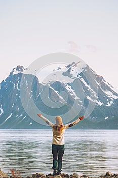 Happy woman hands raised enjoying Norway mountains view