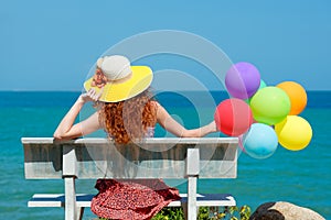 Happy woman in hat with balloons