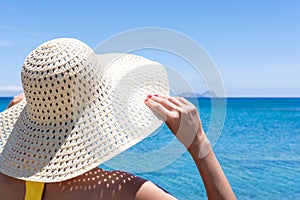 Happy woman in a hat on a tropical beach. Summer vacation concept