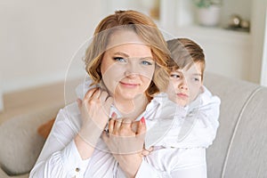 Happy woman have fun with cute baby boy 5-6-7 years old in white shirt. Mom