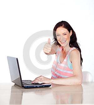 Happy woman having fun with laptop and thumb up