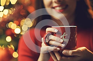 Happy woman having a hot tea at Christmas