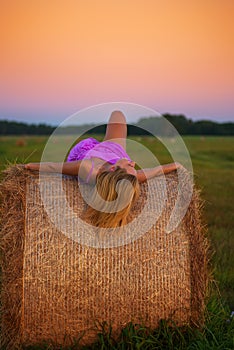 Happy woman with hay in meadow field