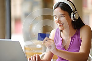 Happy woman with headphone buying online