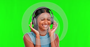 Happy woman, headphones and dancing to music on green screen against a studio background. Portrait of female person