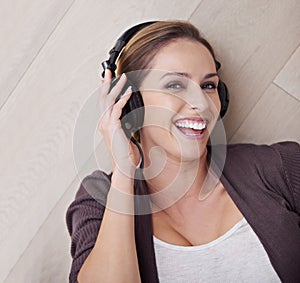 Happy woman, headphones for music and top view with face and listening to song, relax at home with technology. Podcast