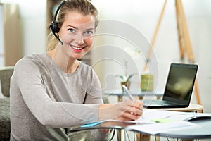 happy woman with headset working on laptop computer