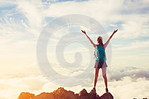 Happy Woman Hiker With Open Arms at Sunset on Mountain Peak