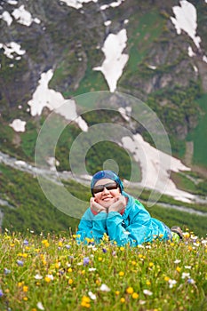 Happy woman hiker on the top of mountain lying down in the grass