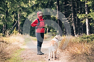 Happy woman hiking with dog in woods