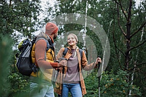 happy woman with hiking sticks walking