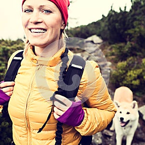 Happy woman hiking in vintage mountains with dog