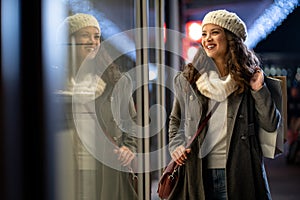 Happy woman hold shopping bags and smiling on city street. Christmas shopping, winter sale concept.