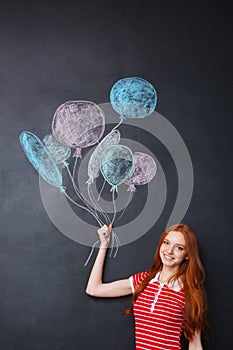 Happy woman holding balloons drawn on blackboard background