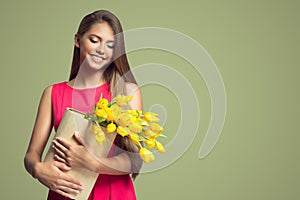 Happy woman holding basket with yellow tulips.