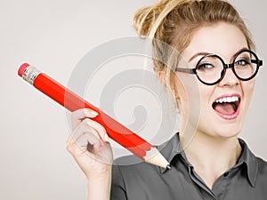 Happy woman holding big oversized pencil