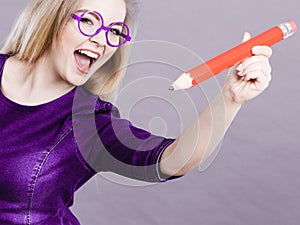 Happy woman holding big oversized pencil