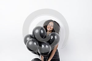 Happy woman holding black balloons