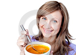 Happy woman holding a bowl with orange soup