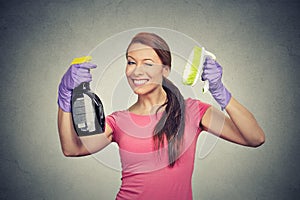 Happy woman holding brush and detergent cleaning solution bottle