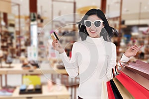 Woman holding credit card and shopping bag at mall