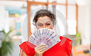 Happy woman holding euro money banknotes
