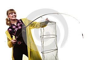 Happy woman holding fishing rod and keepnet