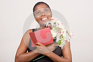 Happy woman holding flowers and a card