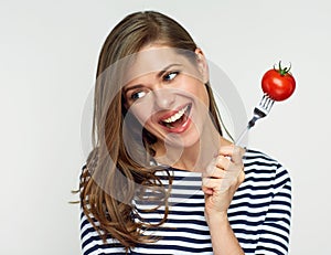 Happy woman holding fork with tomato