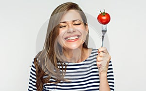 Happy woman holding fork with tomato