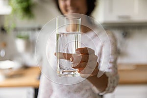 Happy woman holding glass of fresh filtered natural water